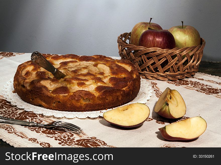 Homemade apple pie surrounded by fresh apples