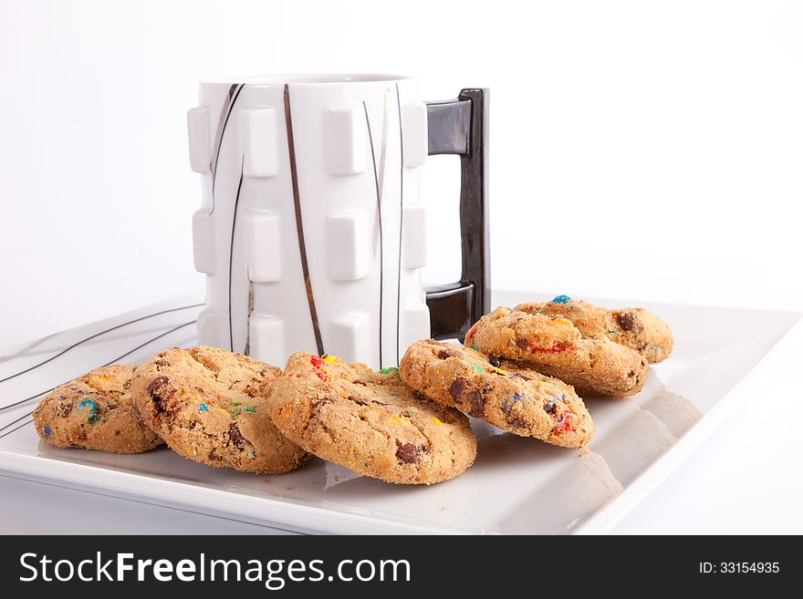 Cup of coffee with cookies staffed colored chocolate on white