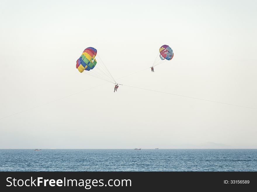A couple having fun parasailing over the sea in holiday. A couple having fun parasailing over the sea in holiday