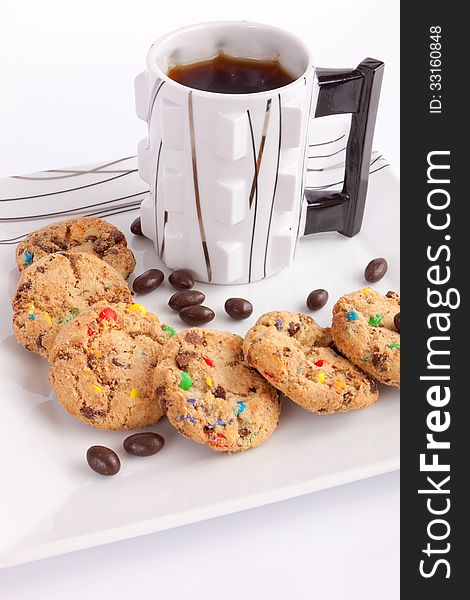Cup of tea with cookies staffed colored chocolate and chocolate on white. Cup of tea with cookies staffed colored chocolate and chocolate on white