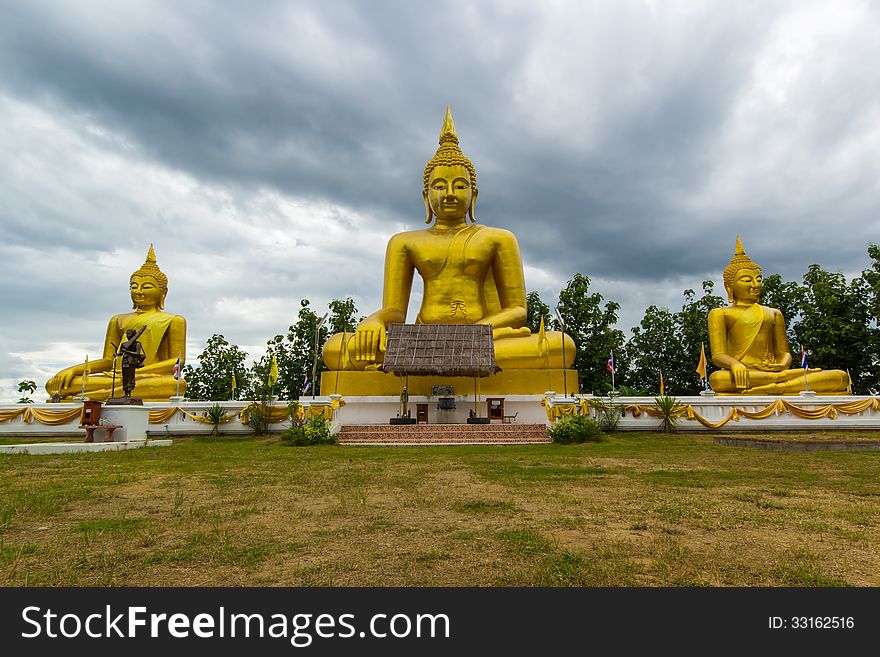 Golden buddha statue under cloudy sky in thailand temple