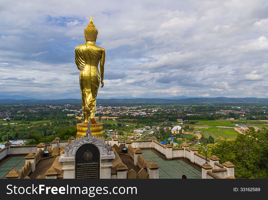 Golden buddha statue under cloudy sky in thailand temple
