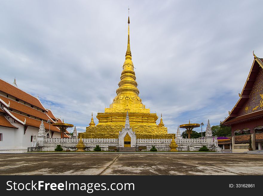 Beautiful golden pagoda in thailand temple under cloudy sky