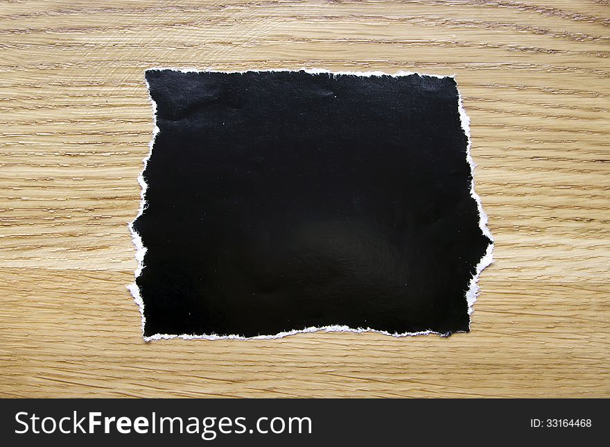 Piece of blank black paper isolated on wooden background. Piece of blank black paper isolated on wooden background