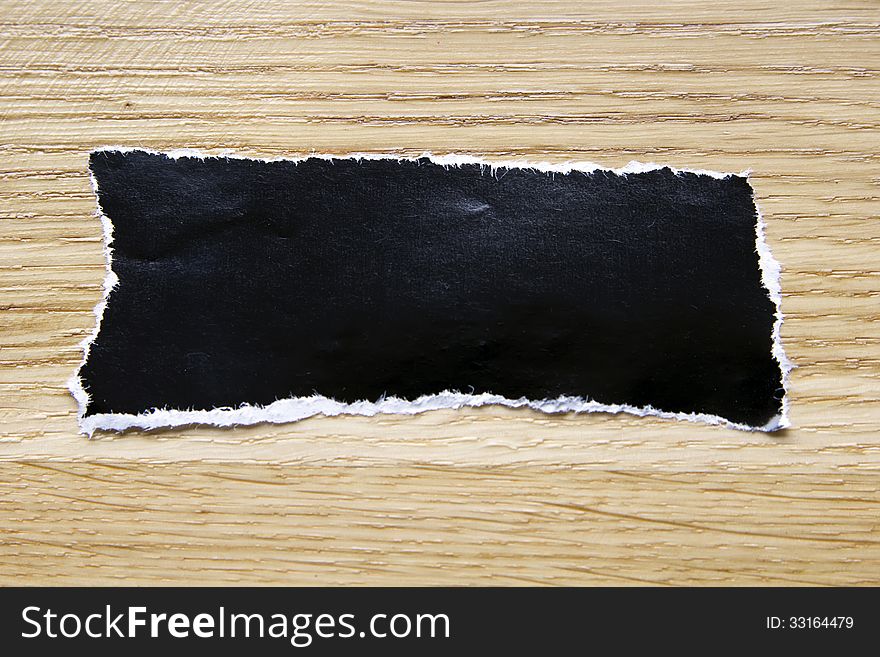 Piece of blank black paper isolated on wooden background. Piece of blank black paper isolated on wooden background