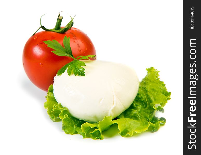 Fresh ball of mozzarella on lettuce leaf with tomato isolated over white