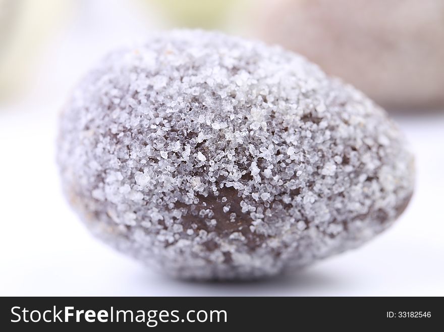 Chocolate stone powdered sugar. Close up. White background.
