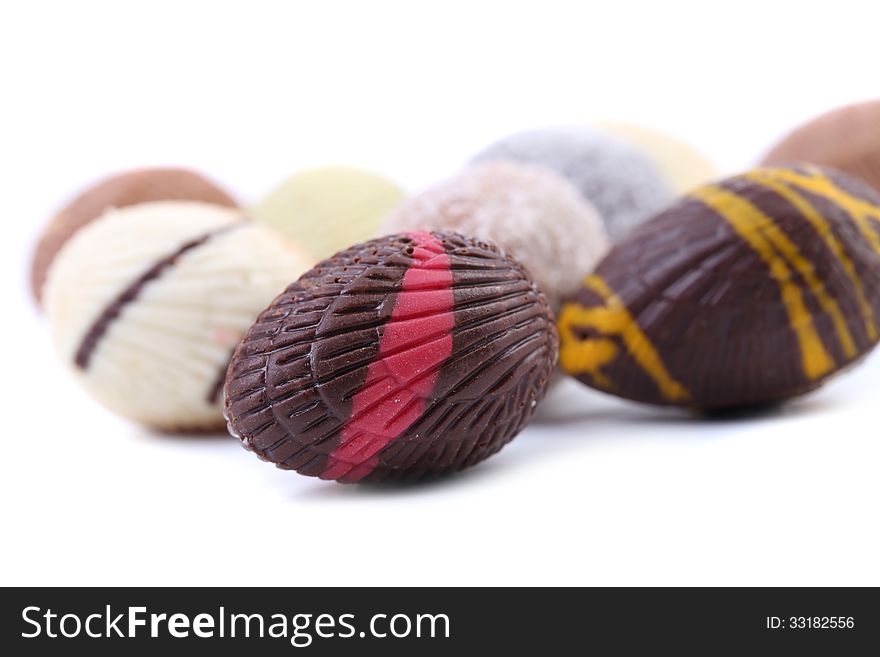 Chocolate seashells and stones. Close up. White background.