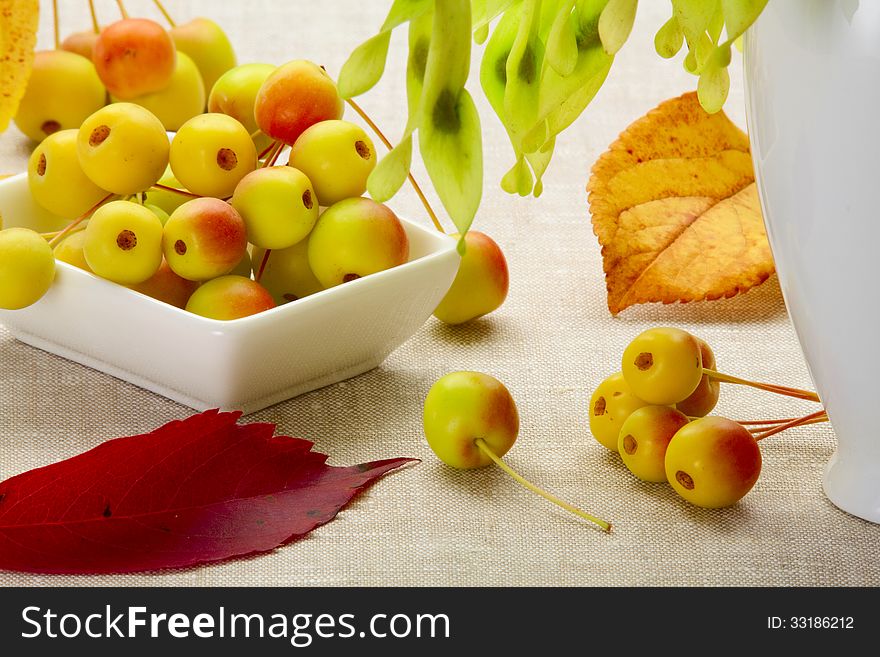 Wild apples in a ceramic bowl near with a vase. Wild apples in a ceramic bowl near with a vase