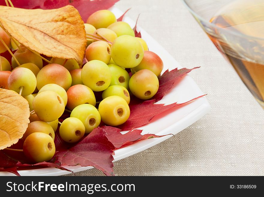 Wild apples and autumnal leaves on a ceramic plate. Wild apples and autumnal leaves on a ceramic plate