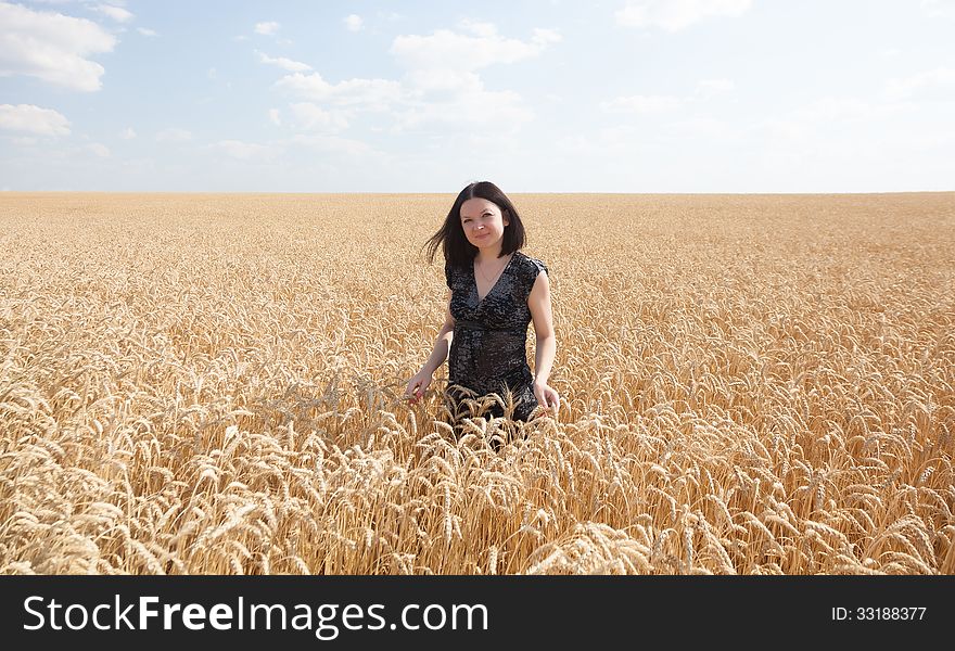 Pretty girl on wheat field summer day