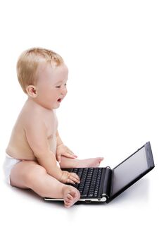 Smiling Baby Typing On A Black Laptop Royalty Free Stock Images