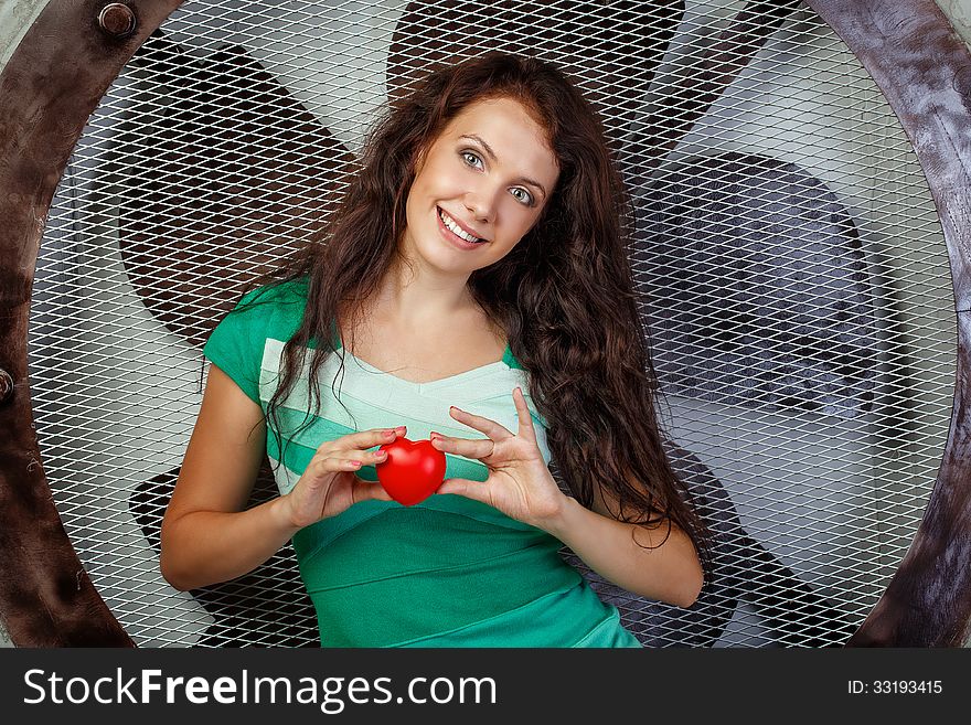 Beautiful girl in a dress holding a heart, photographed in the studio. Beautiful girl in a dress holding a heart, photographed in the studio