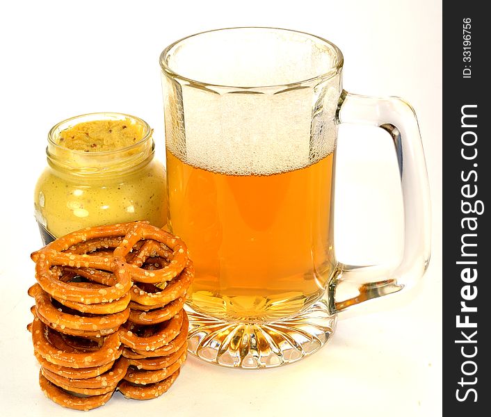 A stack of pretzels with a jar of mustard and a glass of beer. A stack of pretzels with a jar of mustard and a glass of beer.
