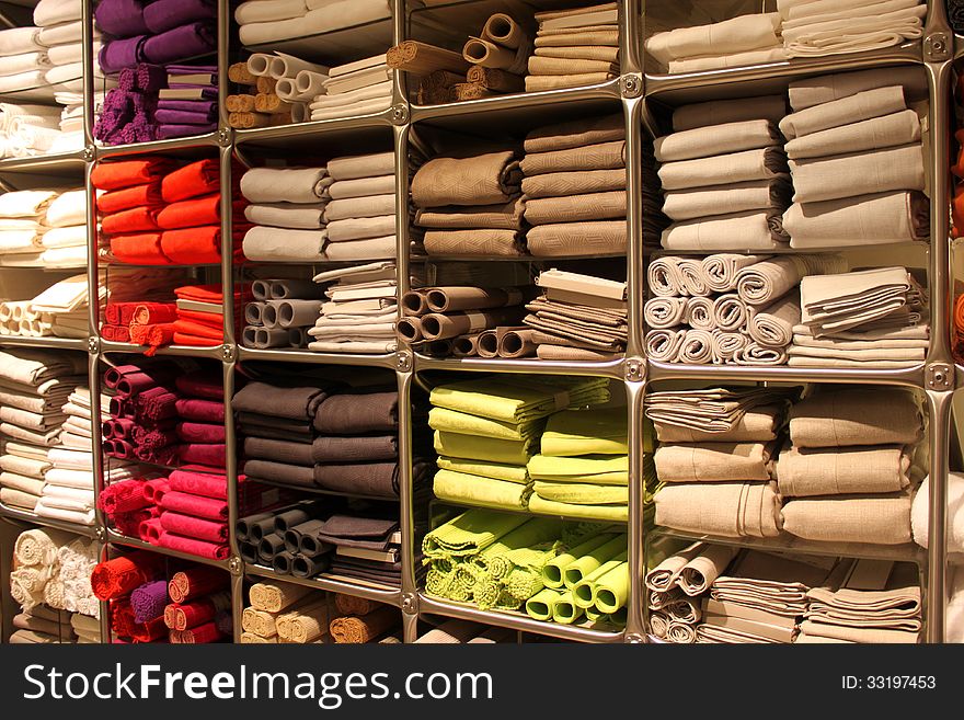 Colored kitchen towels stacked on shelves.Bright rolls of towels.