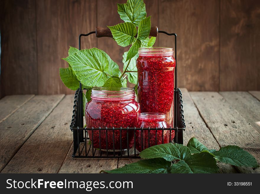 Raspberry Leaves and Jam in a jars on the wooden table