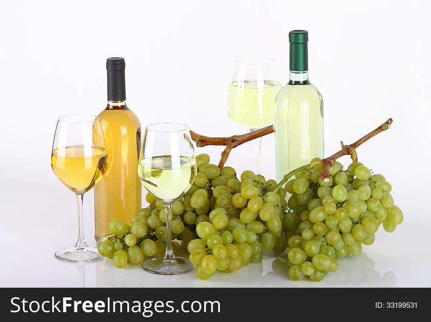 Glasses of white wine with white grapes on white background. Glasses of white wine with white grapes on white background