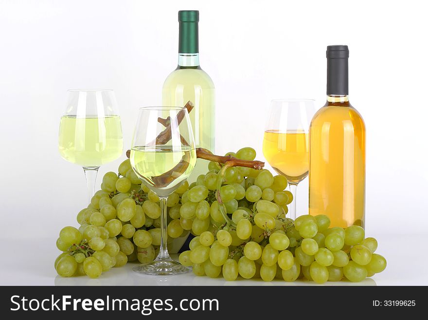Glasses of white wine with white grapes on white background. Glasses of white wine with white grapes on white background