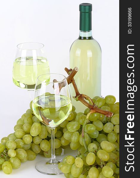 Glasses of white wine with white grapes on white background. Glasses of white wine with white grapes on white background