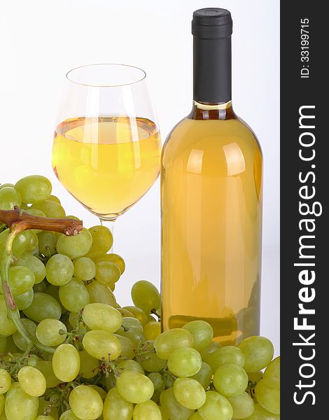 Glass of white wine with bottle and grapes on white background. Glass of white wine with bottle and grapes on white background