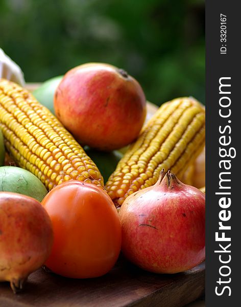 Yellow corn maize and red autumn fruits. Yellow corn maize and red autumn fruits