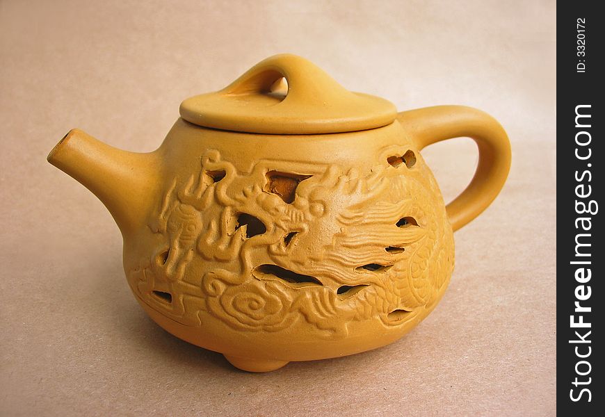 Teapot on brown paper background