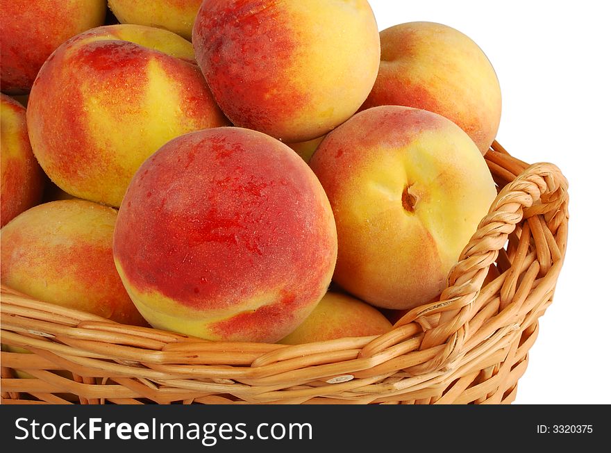 Basket full of fresh peaches isolated on white background