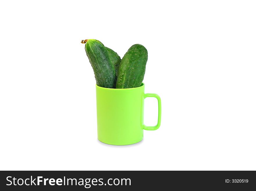 Isolated three green cucumbers in green mug. Isolated three green cucumbers in green mug
