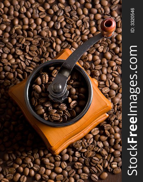 Coffee mill on the background of coffee beans. Coffee mill on the background of coffee beans