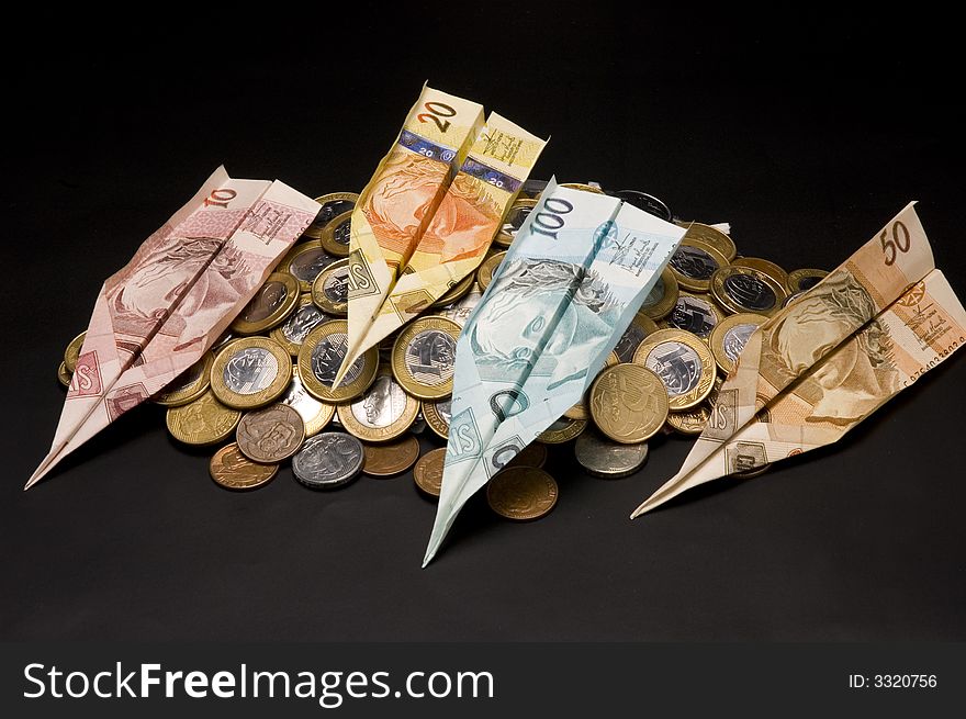 Money airplane and coins on the black background