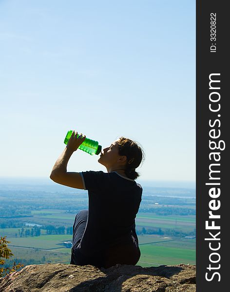 Drinking woman on top of a mountain. Drinking woman on top of a mountain