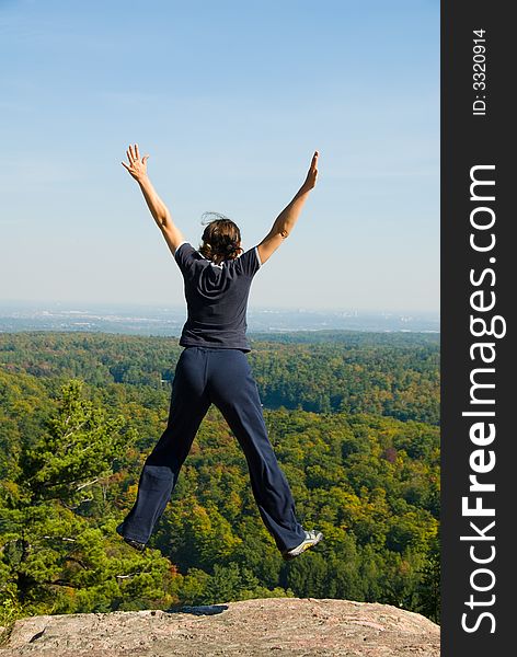 Woman on the top of a mountain happy jumping. Woman on the top of a mountain happy jumping