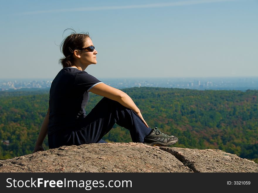 Sitting woman on top of a mountain. Sitting woman on top of a mountain