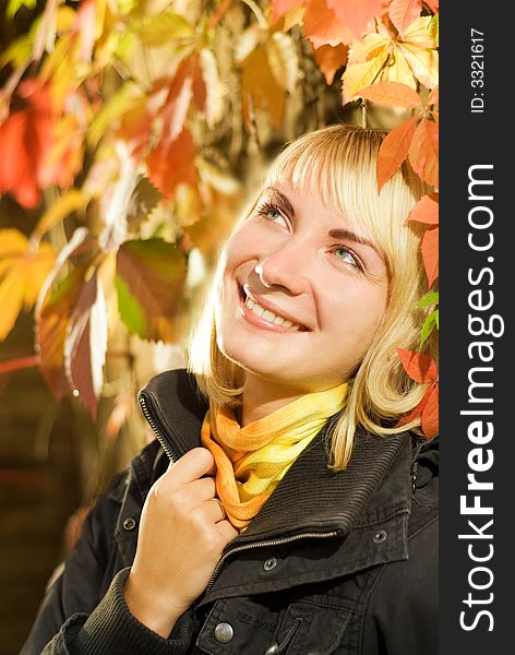 Young blond girl on autumn background