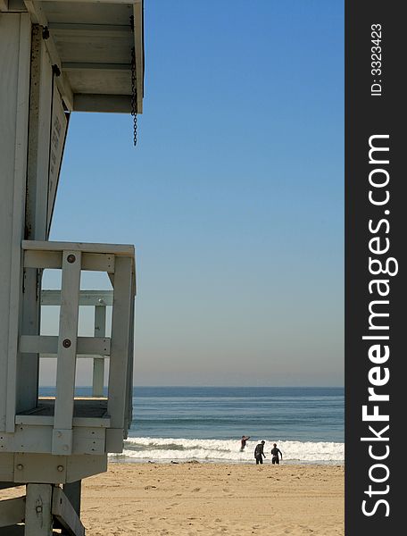 Life-guard cabin on the beach with a people playing in the ocean