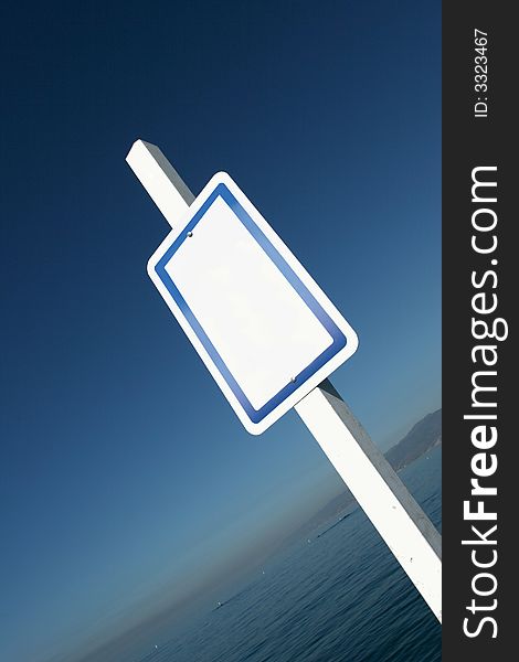 White sign in front of a nice background of blue sky and the ocean. White sign in front of a nice background of blue sky and the ocean