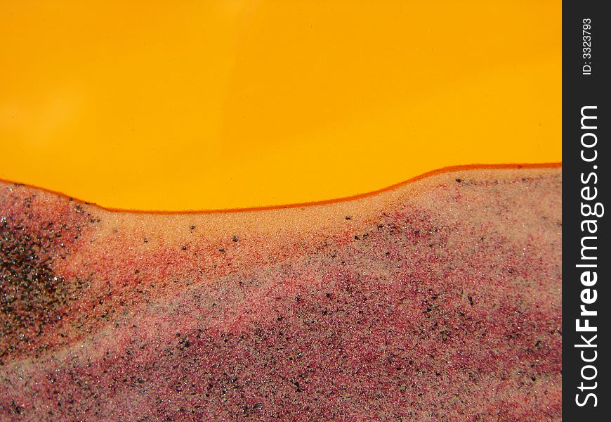 Toy with sand inside, orange background, abstraction