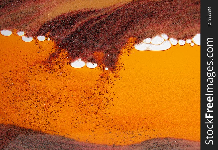 Toy with sand inside, orange background, sand storm