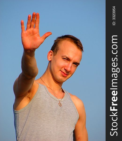 Handsome male greeting with hand in t-shirt. Handsome male greeting with hand in t-shirt