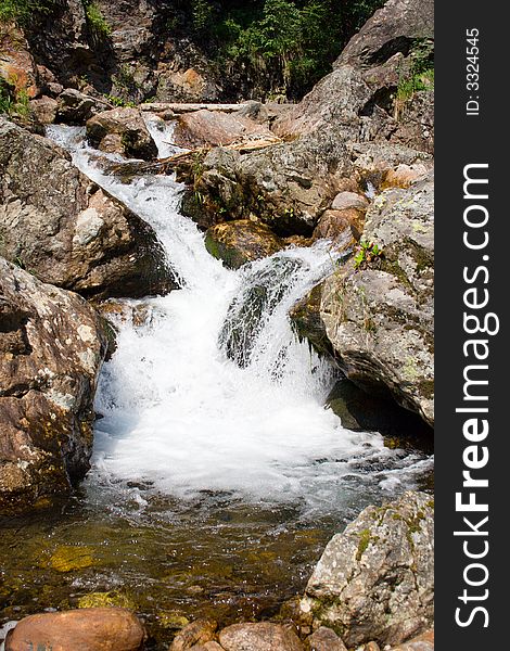 Mountain stream running over mossy rocks in siberia (foothills of Sayan's mountain range)