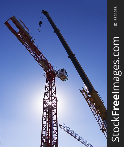 Jobs on installation of the crane on a background of the blue sky. Jobs on installation of the crane on a background of the blue sky