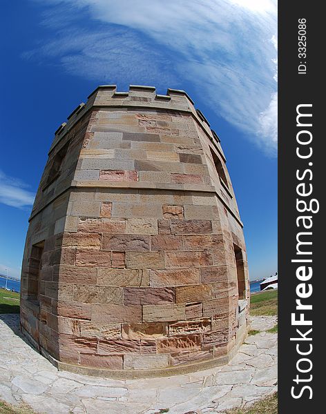 A brick tower in a blue sky & white cloud background in fisheye / ultra-wide angle view, distorted, distortion at La perouse, sydney, nsw, australia. A brick tower in a blue sky & white cloud background in fisheye / ultra-wide angle view, distorted, distortion at La perouse, sydney, nsw, australia