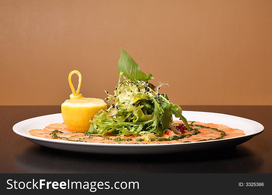 Italian dish: carpaccio with salmon and lemon (lime) and fresh pesto