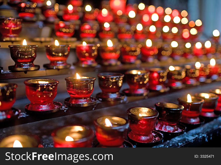 Many little candles in red glass in church. To remembrance. Very small DOF. Many little candles in red glass in church. To remembrance. Very small DOF.