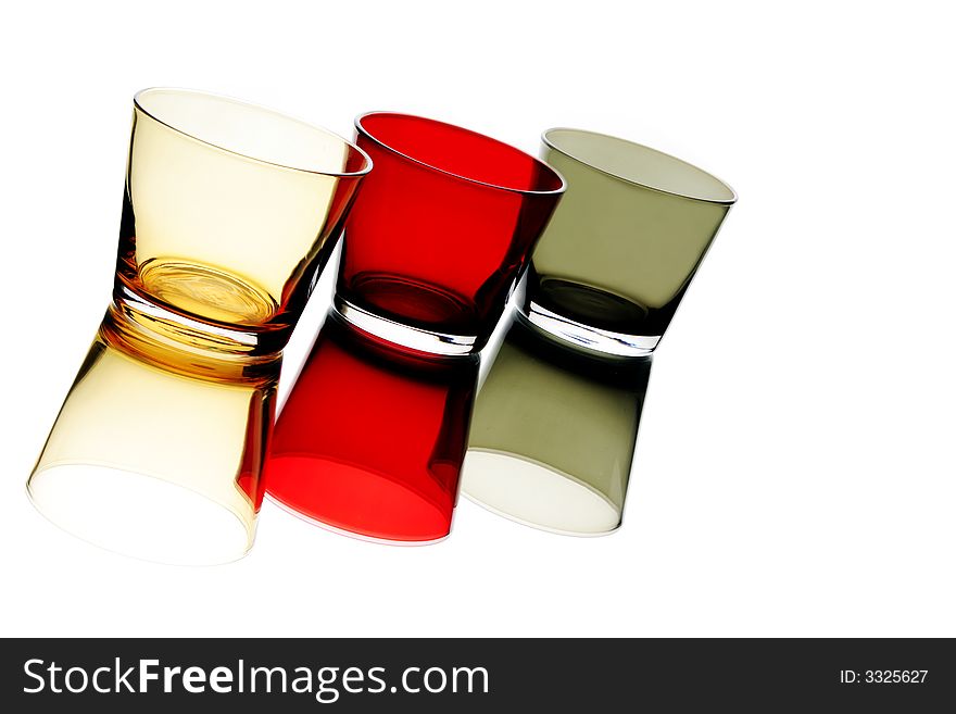 Colorful empty glass over a white reflective background