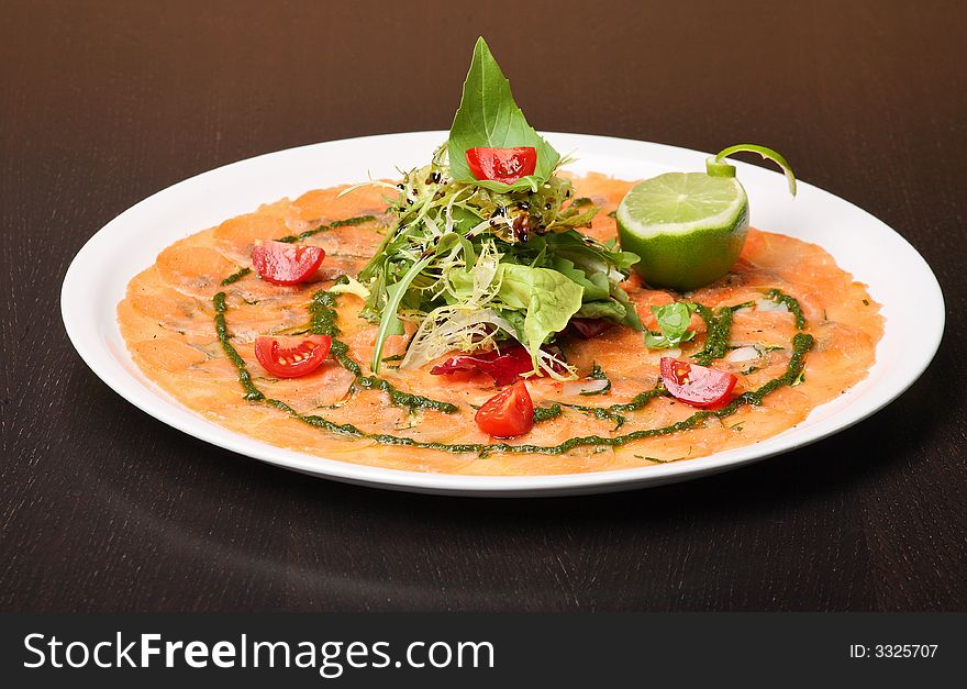 Italian dish: carpaccio with salmon and lemon (lime) and fresh pesto