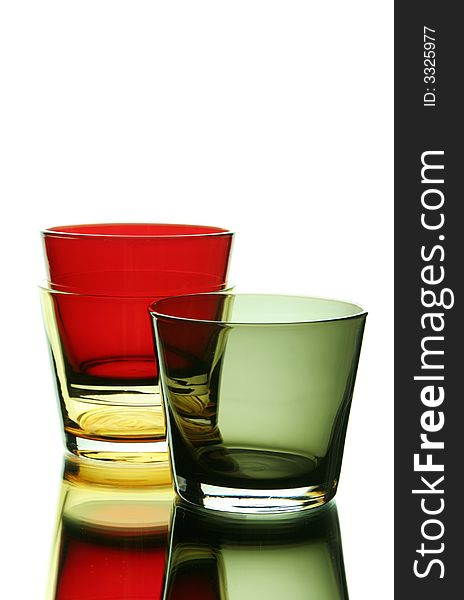 Colorful empty glasses over a white reflective background