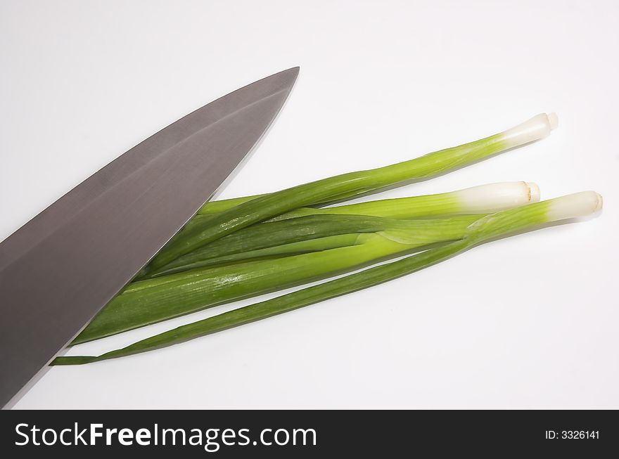 Feathers of a green onions and knife close up