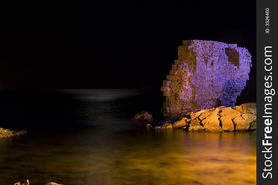Purple rock over night wather with a bit of moon light at the horizon