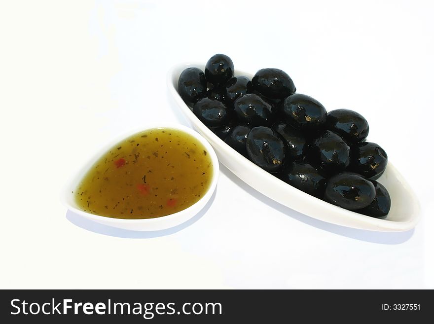 Black olives and sauce in the bowls isolated on the white.